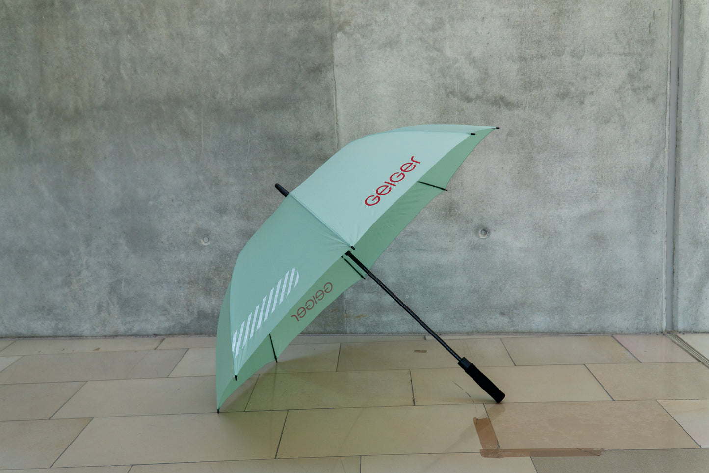 Regenschirm in Geiger-Grün mit "Geiger" Schriftzug