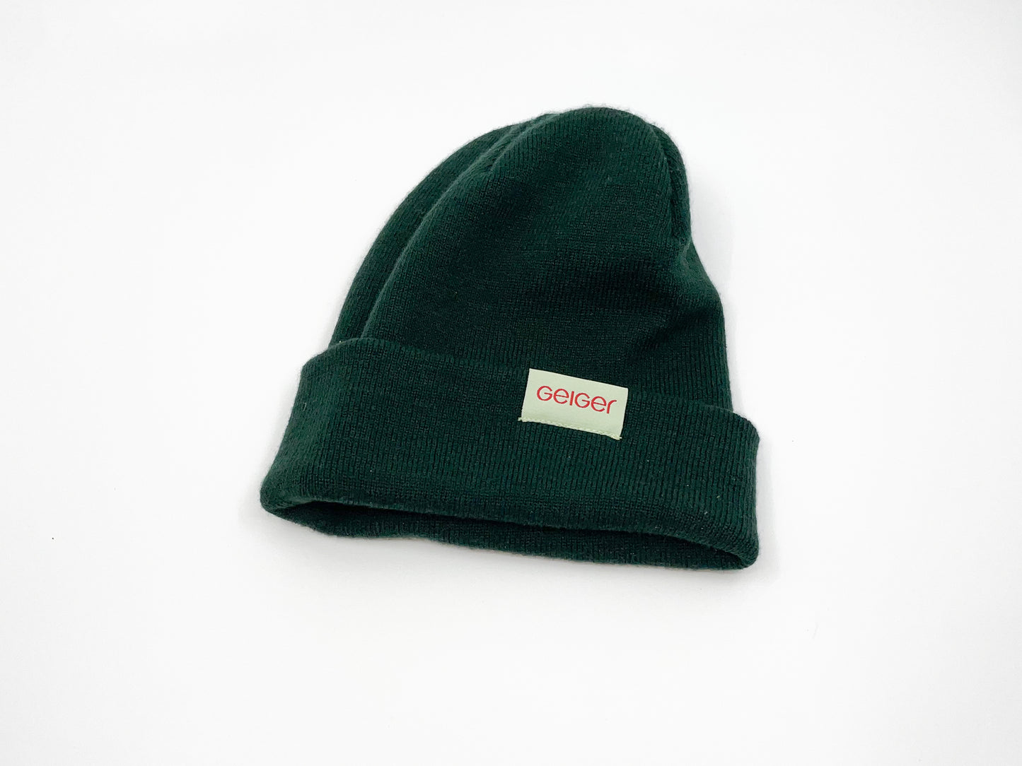 Kiefergrüne Mütze mit Geiger-Grünen Patch an der Seite mit "Geiger" Schriftzug.