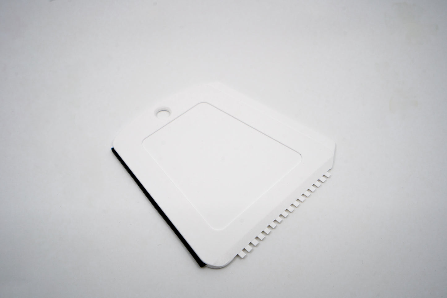 Weißer Kunststoff-Eiskratzer mit rotem "Geiger" Schriftzug.