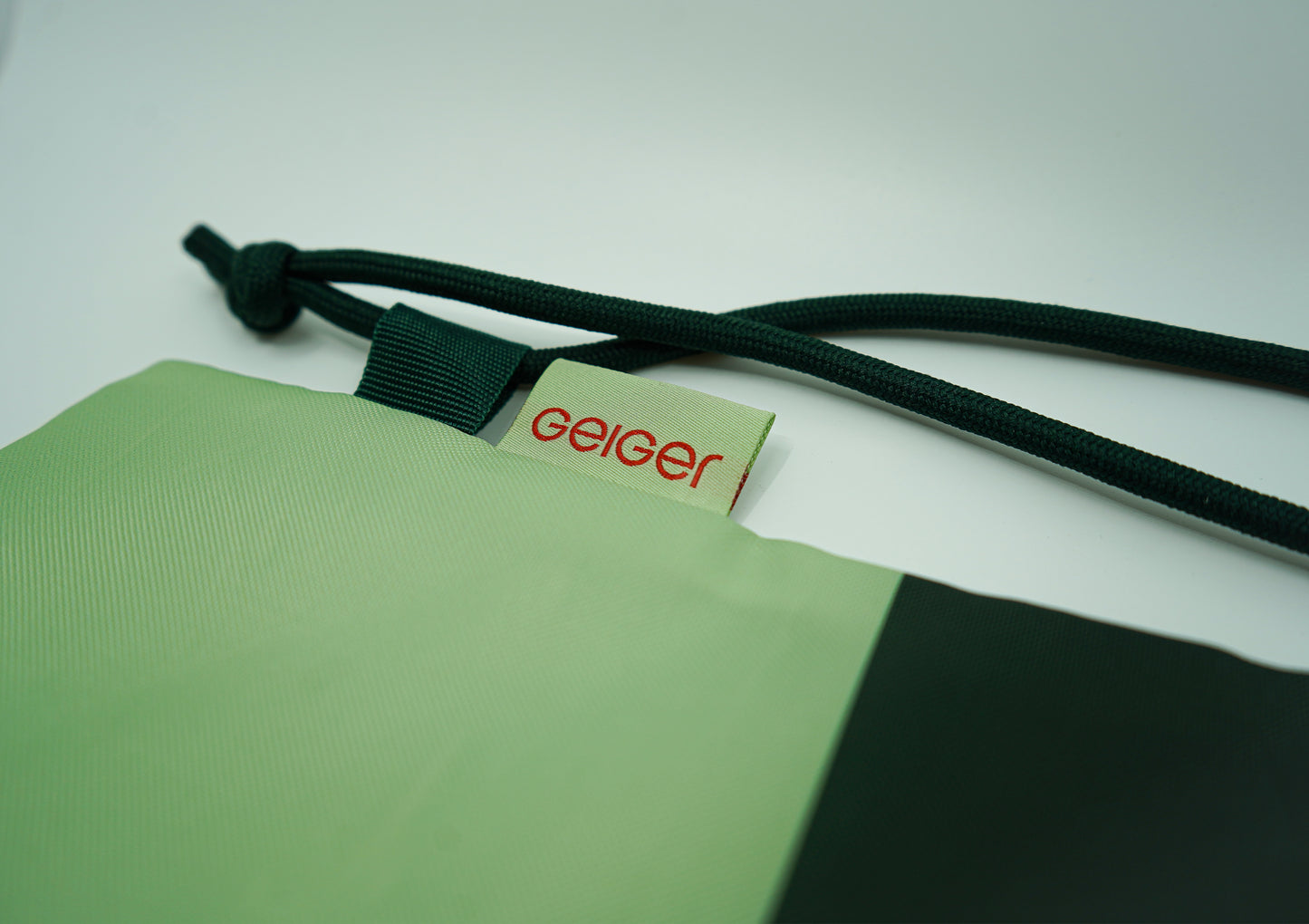 Geiger Sportbeutel in Kiefer- und Geiger-Grün mit rotem „G“ und weißen Designelementen.