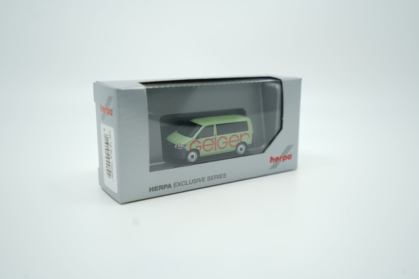 Miniaturmodell eines Geiger VW-Bus in Geiger-Grün mit rotem „Geiger“-Schriftzug, Verpackung inklusive.