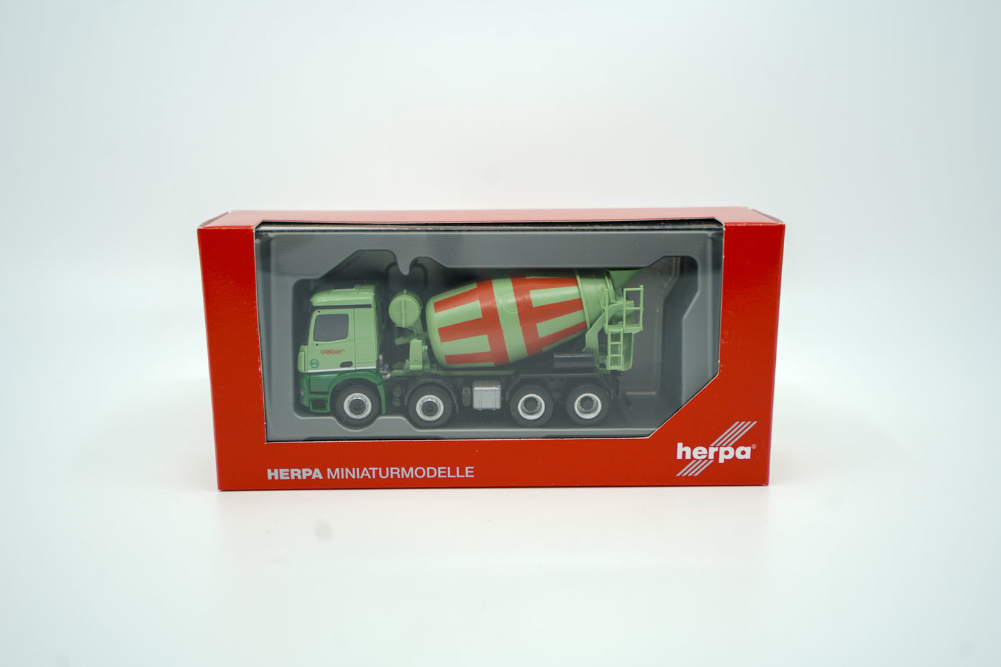 Größeres Miniaturmodell eines Mercedes Betonmischer in Geiger-Grün mit rot-grüner Trommel und "Geiger" Schriftzügen. Verpackung inklusive.