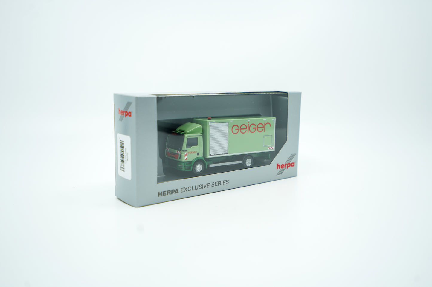 Miniaturmodell eines MAN Geiger-LKW mit geschlossenem Kastenaufbau in Geiger-Grün und rotem "Geiger" Schriftzug. Verpackung inklusive.