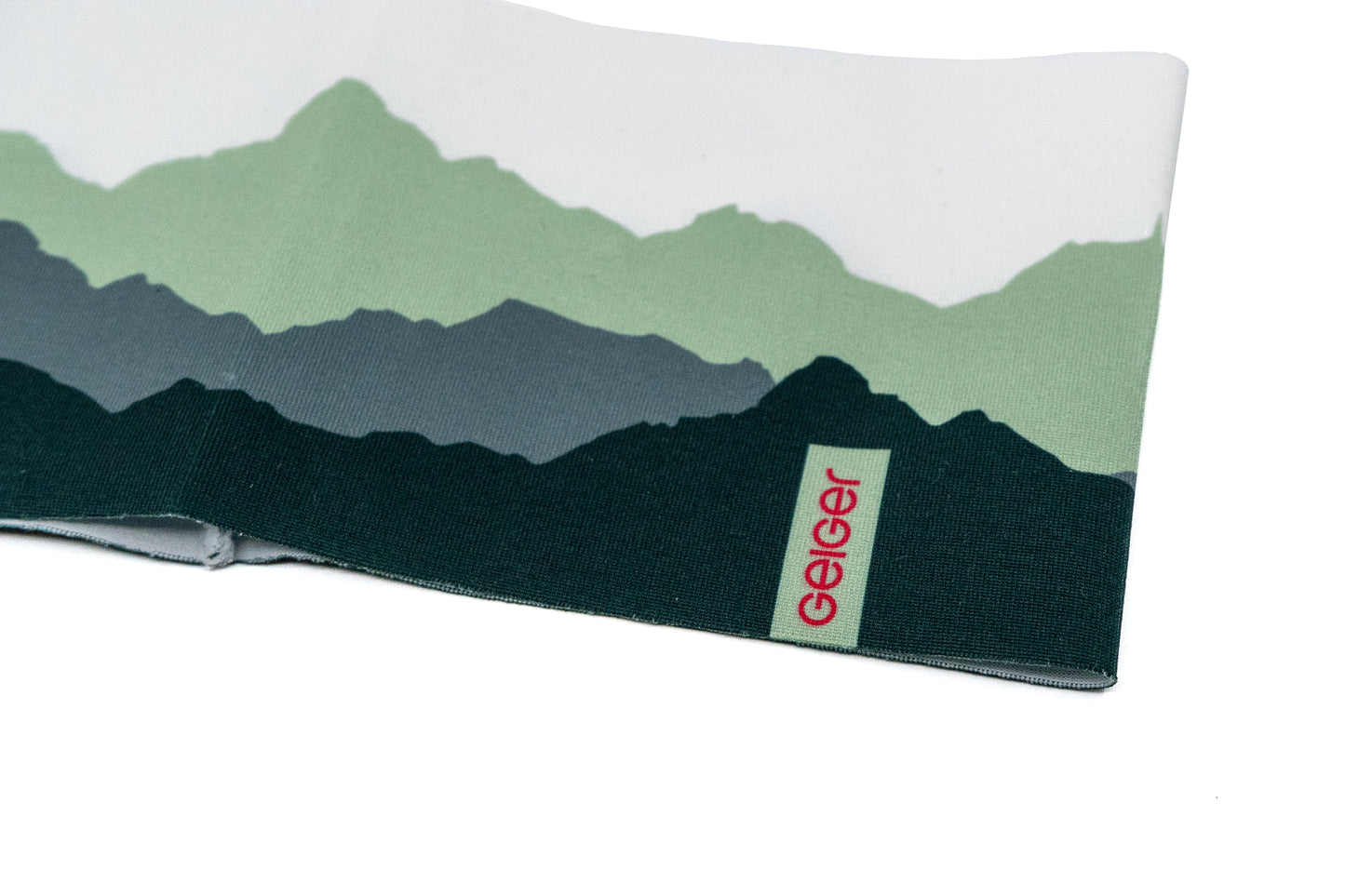 Sportstirnband mit verschiedenen Bergen abgebildet in mehreren Grüntönen und "Geiger" Schriftzug auf einem Patch.