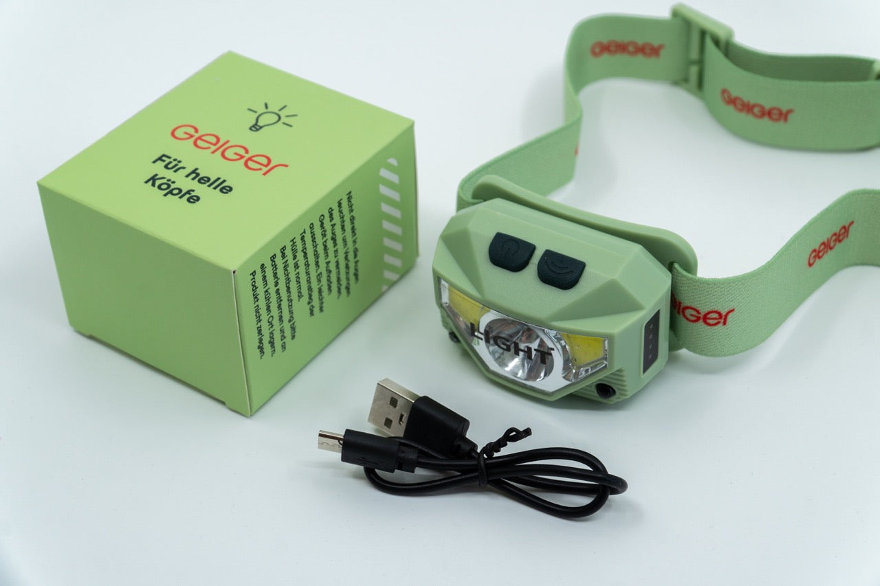 Stirnlampe im Geiger-Grün mit Grünen Band mit "Geiger" Schriftzug. Ladekabel inklusive.