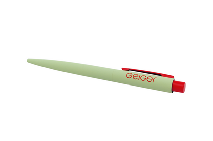 Geiger Kugelschreiber in Geiger-Grün mit roter Klammer und roten Knopf. Auf dem Stift ist ein "Geiger" Schriftzug