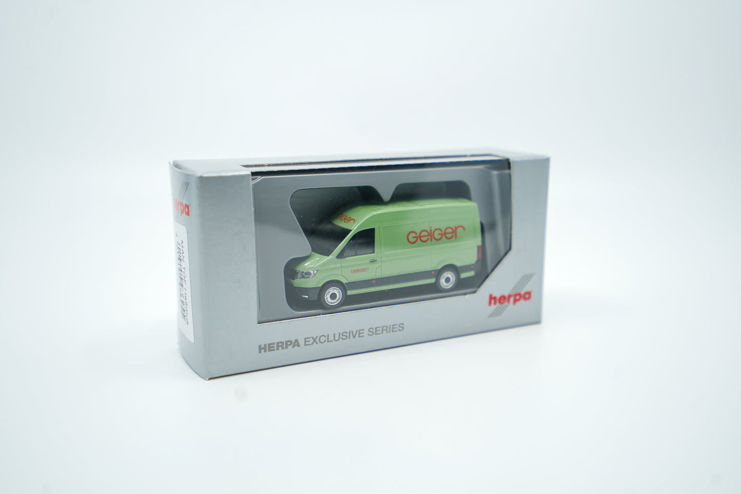 Miniaturmodell eines Geiger MAN-Transporters / Halbbus in Geiger-Grün mit rotem „Geiger“-Schriftzug, Verpackung inklusive.