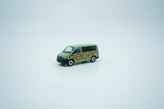 Miniaturmodell eines Geiger VW-Bus in Geiger-Grün mit rotem „Geiger“-Schriftzug, Verpackung inklusive.