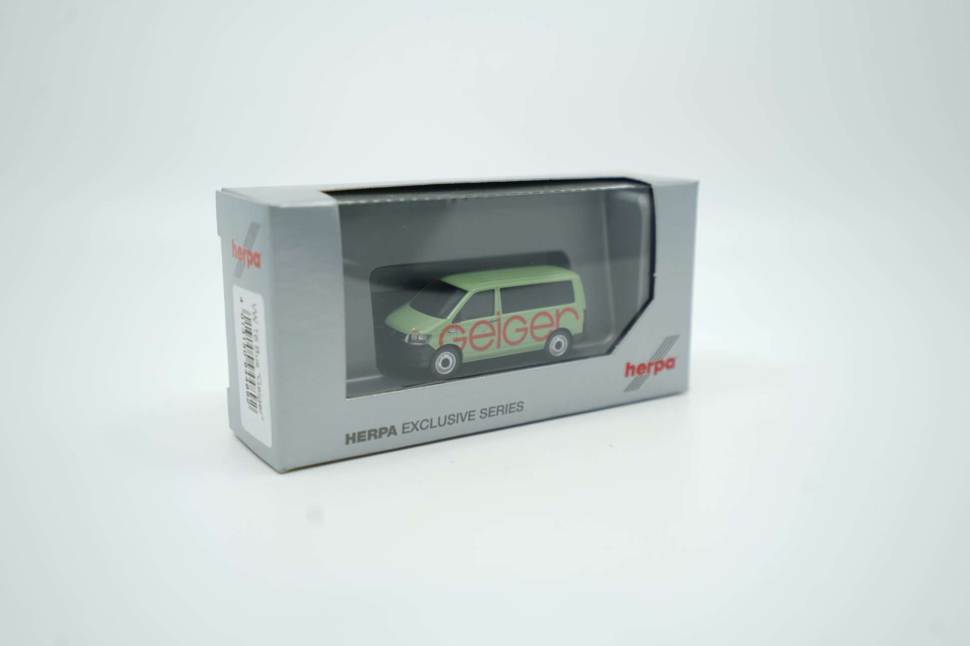 Miniaturmodell eines Geiger VW-Bus in Geiger-Grün mit rotem „Geiger“-Schriftzug, Verpackung inklusive.