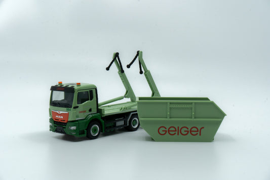 Miniaturmodell eines MAN Geiger-Containerservice-Fahrzeugs in Geiger-Grün mit rotem "Geiger" Schriftzug. Verpackung inklusive.