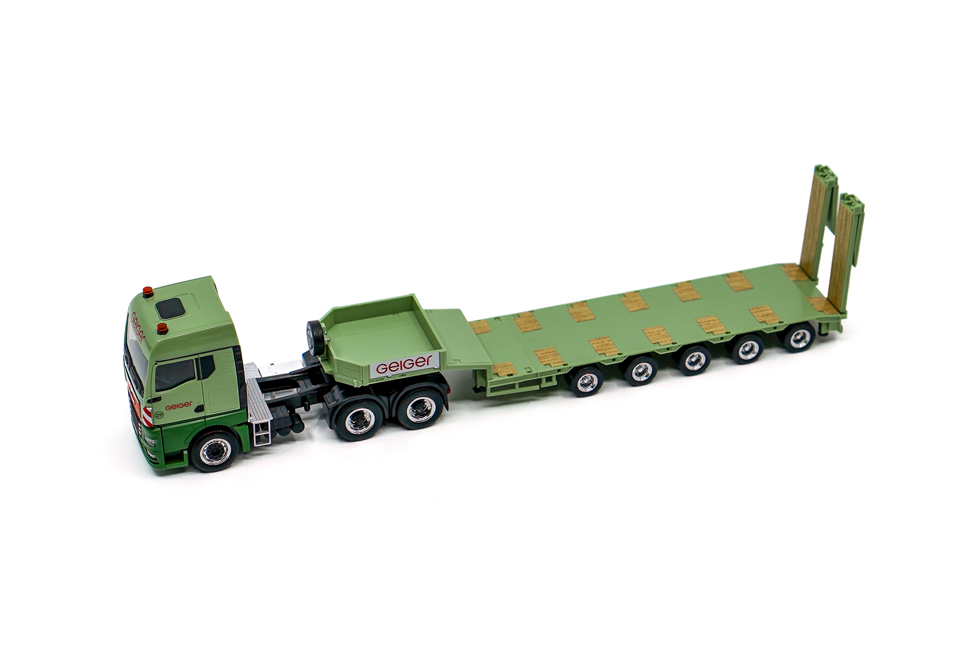 Miniaturmodell eines Geiger MAN TGX GM Semitieflader-Sattelzug in Geiger-Grün mit rotem „Geiger“-Schriftzug.