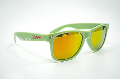 Sonnenbrille in Geiger-Grün mit roten „Geiger“-Schriftzügen an den Bügeln und verspiegelten Gläsern.